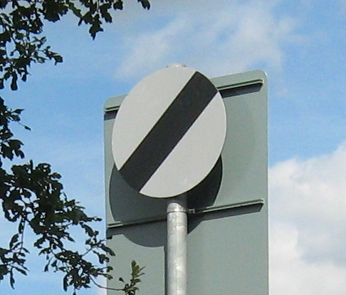 national speed limit sign, white circle with black diagonal